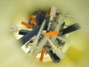 A container full of used drug needles.