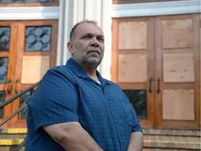 Joseph Tawfik, Treasurer of St. Mary and St. Moses Coptic Orthodox Church, stands in front of the church's boarded up front doors May 28, 2018, after a vandal smashed the glass a few nights prior.