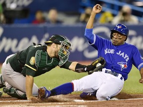 Toronto Blue Jays' Curtis Granderson, right, is tagged out at home plate by Oakland Athletics catcher Josh Phegley (19) during first inning American League baseball action in Toronto on Friday, May 18, 2018.