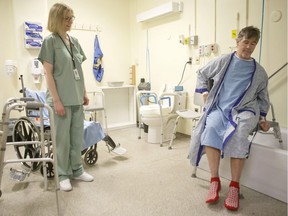 Physiotherapist Ellen Newbold watches as Tim Heenan practices his technique for getting into a bath as prepares for his release follow a day surgery for a hip replacement that morning at Toronto's St.Michael's Hospital on Tuesday May 23, 2018.