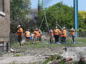 A team does a historical dig behind the last remaining home on Indian Road on Thursday, May 24, 2018. The land is owned by the Ambassador Bridge company.