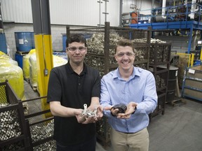Artisan Metal Finishing operation manager Brian Carter (left) and general manager Dave Priestly hold Toyota auto parts in London. (DEREK RUTTAN, The London Free Press)