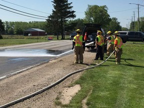 LaSalle firefighters hose down the surface of Malden Road near Golf View Drive after a serious collision between two vehicles on the morning of May 24, 2018.