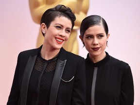 Tegan Quin, left, and Sara Quin of the musical group Tegan and Sara arrive at the Oscars on Feb. 22, 2015, at the Dolby Theatre in Los Angeles. Twin sisters Tegan and Sara are putting their names behind social causes in a bigger way than ever this year.