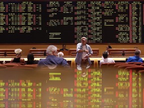 People sit in the sports book at the South Point hotel-casino, Monday, May 14, 2018, in Las Vegas. The Supreme Court on Monday gave its go-ahead for states to allow gambling on sports across the nation, striking down a federal law that barred betting on football, basketball, baseball and other sports in most states.