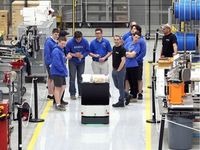 Team Wiredcats of Villanova High School explore an automatic guided vehicle during their tour of Reko Automation Division in Lakeshore on Monday.