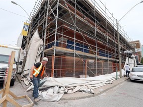 Sandblasting specialist Joe Mallen of Manz Contracting Services Inc. drops a huge tarp to reveal original brick on the exterior of the Old Fish Market at Ferry and Chatham streets June 5, 2018. The brick was found to be in good shape and the brick will be powerwashed and resealed with clear coat.  In a few weeks, developers Dino Maggio and his son, Anthony Maggio will be installing new windows.