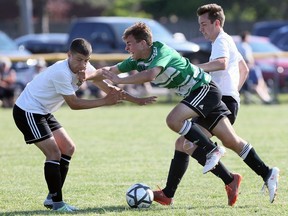 Sam Publicover, centre, of St. David, loses control against Essex defenders Andrew Mastroianni, left, and Jayden McTavish, right, during an OFSSA AA boys soccer game between Essex and St. David at L'Essor Field 3, June 8, 2018.