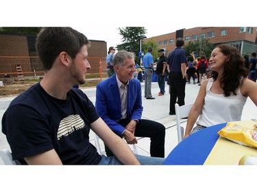 University President Alan Wildeman, centre, chats with masters students Frederik Ehlen, left, and Kathrin Holzhauer during University of Windsor annual community barbeque to welcome students back on Sept. 9, 2015.