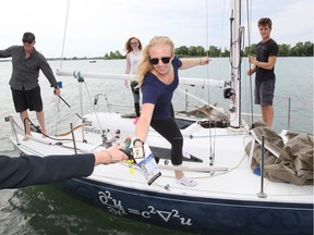 Bailey Yildiz, aboard the vessel Equation, receives the Commodore's Greeting attached to a bottle of Canadian Club whiskey near the start of Windsor Yacht Club's 46th Annual Canadian Club Overnight Race on the Detroit River and Lake St. Clair June 15, 2018.