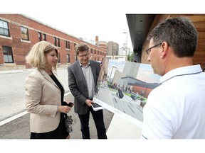 Sandra Aversa, left,  University of Windsor's VP planning and administration, is joined by Craig Goodman of CS and P Architects and Mark Winterton, right, City of Windsor engineer, during a community open house for a pedestrian corridor and green space on Freedom Way June 19, 2018.