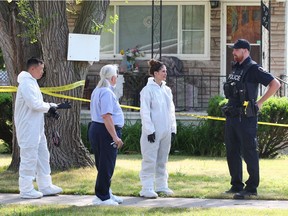 Windsor Police forensics members David Liu, left, Khrystye Hamlin along with Const. Harry Young, right, confer with coroner Dr. Merven Oxley at 1497 Everts Avenue June 20, 2018.  Windsor Police are investigating the death of man at the single-family home as the city's fifth homicide.