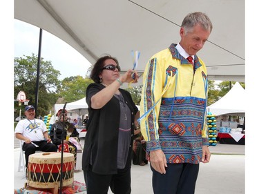 Alan Wildeman receives a 'ribbon shirt' from Bernie Riley during official dedication of Turtle Island Walk, the pedestrian corridor that has replaced a stretch of Sunset Avenue from Wyandotte Street West to University Avenue West on Sept. 21, 2017.