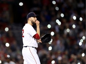 Fans shine the lights on their cell phones in the stands as Matt Barnes of the Boston Red Sox looks on during the seventh inning against the Detroit Tigers at Fenway Park on June 6, 2018 in Boston, Massachusetts.