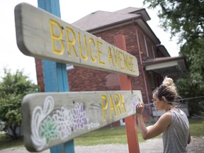 Local artist Victoria Hillier paints flowers onto the Bruce Avenue Park sign, Thursday, June 21, 2018.  Hillier is painting the flowers as part of the annual Spruce up Bruce which this year is in collaboration with the United Way's Day of Caring.