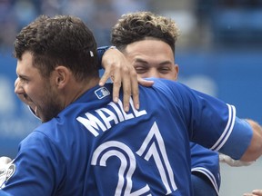 Toronto Blue Jays' Luke Maile (21) celebrates his bases loaded walk-off RBI walk to defeat the Baltimore Orioles with teammate Gio Urshela in the tenth inning of their American League MLB baseball game in Toronto on June 9, 2018.