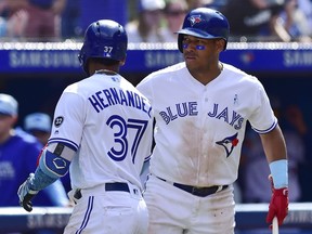 Toronto Blue Jays left fielder Teoscar Hernandez (37) is congratulated by Yangervis Solarte after hitting a solo home run against the Washington Nationals during eighth inning interleague baseball action in Toronto on  June 17, 2018.