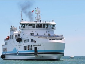 The $40-million Pelee Islander II dwarfs a curious pleasure boat as it steams into the Kingsville Dock on June 15, 2018.