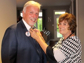 Progressive Conservative candidate Rick Nicholls gets his tie straightened by his wife Dianne, shortly before leaving to meet his supporters in Chatham, Ont. on election night,  Thursday June 7, 2018.