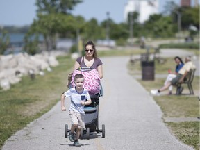 Chrissy Nicodermo pushes two-month-old Sofia, while Mark, 4, runs ahead during a walk along the riverfront on June 14, 2018.
