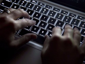 Hands type on a laptop keyboard in this photo illustration.