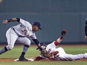 Boston Red Sox's Andrew Benintendi, right, eludes a tag by Detroit Tigers second baseman Dixon Machado during the first inning of a baseball game at Fenway Park in Boston, Tuesday, June 5, 2018.