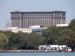 The Michigan Central Station building looms behind the Ambassador Bridge on the Detroit side of the border in this September 2017 file photo.