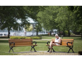 AMHERSTBURG, ONT:. JUNE 8, 2018 -- Audrey Lavigne, who lives in a nearby condominium, reads while sitting on a park bench at the Navy Yark Park in Amherstburg, Friday, June 8, 2018.