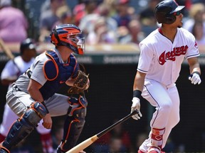 Cleveland Indians' Michael Brantley, right, watches his two-RBI single in the second inning of a baseball game against the Detroit Tigers, Sunday, June 24, 2018, in Cleveland.