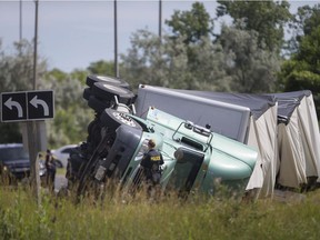 OPP officers inspect a transport truck that rolled onto its side on the E.C. Row eastbound on ramp at Huron Church Road, Thursday, June 21, 2018.  The on ramp was temporarily closed and it's unknown if there were injuries. The accident followed an OPP blitz last week. Nearly 700 charges were laid against transport truck drivers and 63 trucks were taken out of service. Speeding led the list of offences, with 226 charges being laid. Defective equipment ranked second at 176 charges.