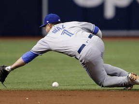 Toronto Blue Jays shortstop Aledmys Diaz dives but can't get to a single by Tampa Bay Rays' Jake Bauers during the first inning of a baseball game Tuesday, June 12, 2018, in St. Petersburg, Fla.