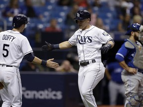 Tampa Bay Rays' Jake Bauers, center, celebrates with Matt Duffy, left, after Bauers hit a two-run home run off Toronto Blue Jays pitcher Sam Gaviglio during the fourth inning of a baseball game Monday, June 11, 2018, in St. Petersburg, Fla. Catching for the Blue Jays is Russell Martin.