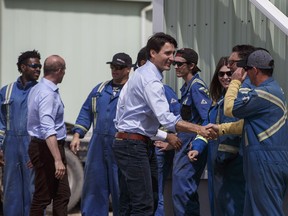 Prime Minister Justin Trudeau shakes hands with workers as he visits Kinder Morgan in Edmonton, Alta, on June 5, 2018.