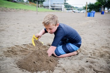 A young boy plays in the sand at Colchester Beach.