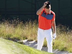 Jordan Spieth checks his lie in a bunker on the 11th hole during the first round of the U.S. Open Golf Championship, Thursday, June 14, 2018, in Southampton, N.Y.