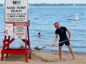 In this July 4, 2018, file photo, lifeguard Justin Folkeringa shovels sand into a pile at the base of his lifeguard stand at Sand Point Beach. Windsor's municipal beach had some of the safest water quality measurements this week.