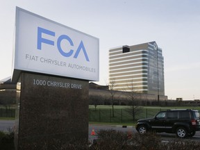 FILE - In this Tuesday, May 6, 2014, file photo, a vehicle moves past a sign outside Fiat Chrysler Automobiles world headquarters in Auburn Hills, Mich.
