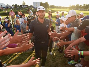 Dustin Johnson celebrates his winning putt on the 18th hole by greeting fans as he exits the course during the final round at the RBC Canadian Open at Glen Abbey Golf Club on July 29, 2018, in Oakville.