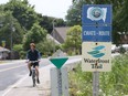 A cyclist rides eastbound on a paved trail along County Road 50 near Becker Lane in Kingsville, Ontario on July 23, 2018.