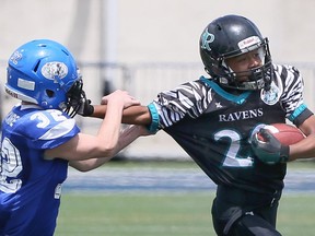 Windsor, Ontario. July 28, 2018.  Essex Ravens Jaydon Bush uses a stiff arm against Cumberland's Isaac Dicaire, left, during the second half of the Ontario Provincial Football Leauge bantam championship game at University of Windsor Alumni Stadium, Saturday July 28, 2018.  (NICK BRANCACCIO/Windsor Star).