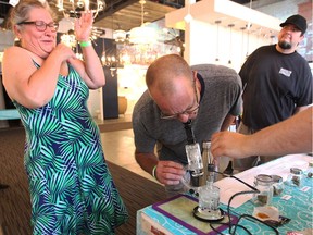 A medical marijuana user, left, reacts to a sampling of product during a cannabis pop-up market in Ford City on July 29, 2018. The woman was joined by her spouse, centre, and others during the impromptu five-hour Windsor event on Sunday.