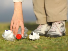 A woman picks up trash in park.