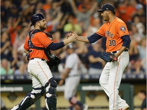 Hector Rondon #30 of the Houston Astros shakes hands with catcher Max Stassi #12 after the final out against the Detroit Tigers at Minute Maid Park on July 13, 2018 in Houston, Texas.