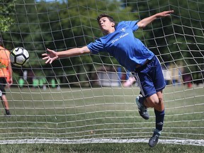 Aidan Belcastro, 13, tries to make a save in goal during a soccer camp at Green Acres Optimist Park in Tecumseh, ON. on Friday, July 6, 2018.