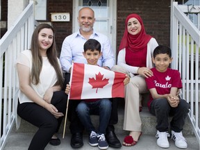 Khaled El-Mostapha with his wife, Sana Dabour, and three children from left to right, Alaa Salameh, Yousef El-Mostapha, and Mohammed El-Mostapha, are pictured on their front porch.  Khaled and his two boys became Canadian citizens on Canada Day.