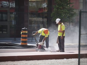 Construction crews along a downtown stretch of Ouellette Avenue are shown July 19, 2018, tearing up recently laid concrete a city inspection deemed substandard.