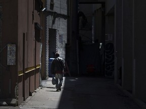 Let there be light. The DWBIA is seeking contractors to install lighting in several downtown alleys to improve safety. In this May 8, 2018, file photo, a man walks down the alley behind the Pelissier Street parking garage.