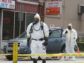 Hazardous materials experts with Windsor police examine a Ford Escape in which an unknown powdery substance was found in the 3600 block of Sandwich Street on July 31, 2018.