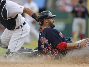 Boston Red Sox's J.D. Martinez, right, is tagged out by Detroit Tigers catcher James McCann as he tries to score from third during the first inning of a baseball game, Friday, July 20, 2018, in Detroit.