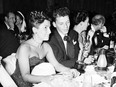 In this March 11, 1946 file photo, at a crowded table at Ciro's, Frank Sinatra steals a glance at his Oscar which he won for his performance in the film "The House I Live In," as his wife Nancy looks on at left.